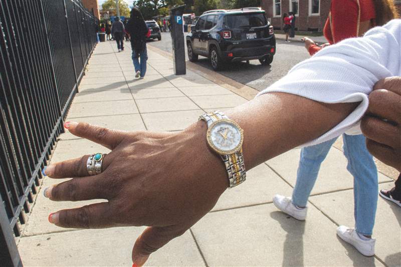 一個(gè)戴著手表的人，指甲上涂著彩色的法式尖頭